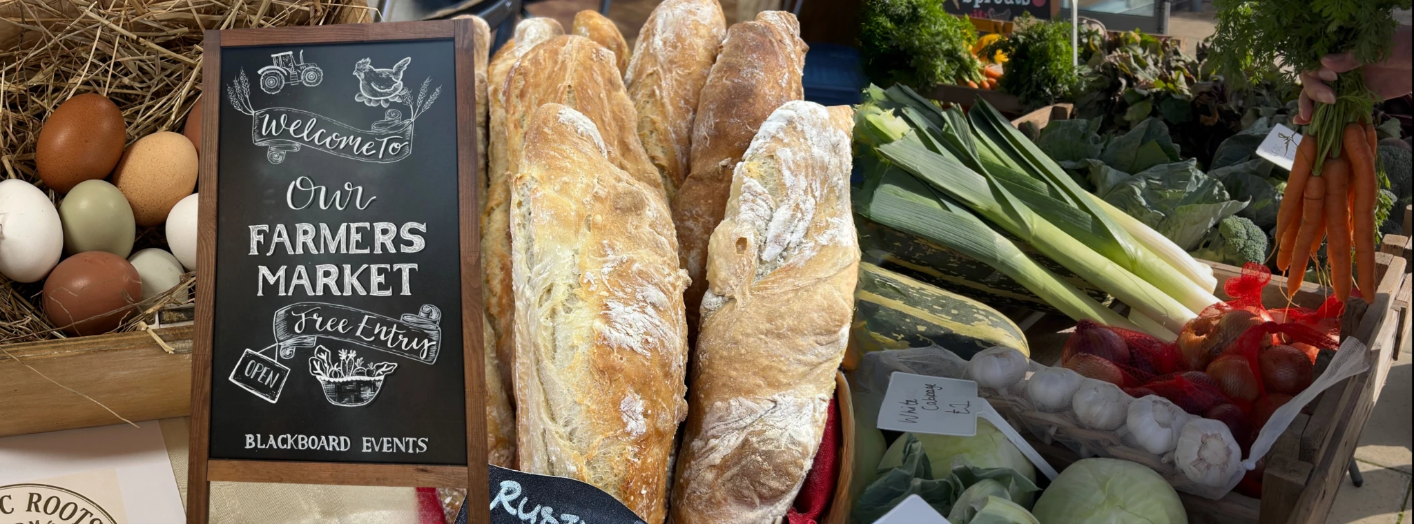 Eggs, a farmers market welcome chalkboard, fresh bread and vegetables