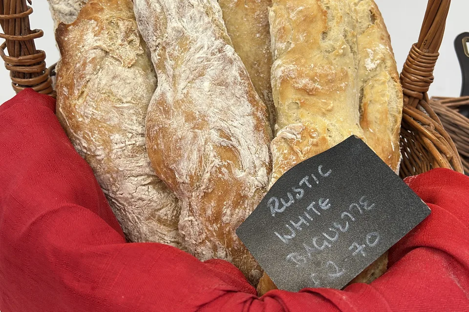 Rustic white baguettes in a wicker basket lined with a red cloth