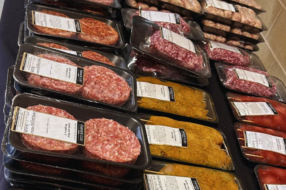 Farmer Lou trays of burgers, sausages and marinated chicken skewers laid out on a stall