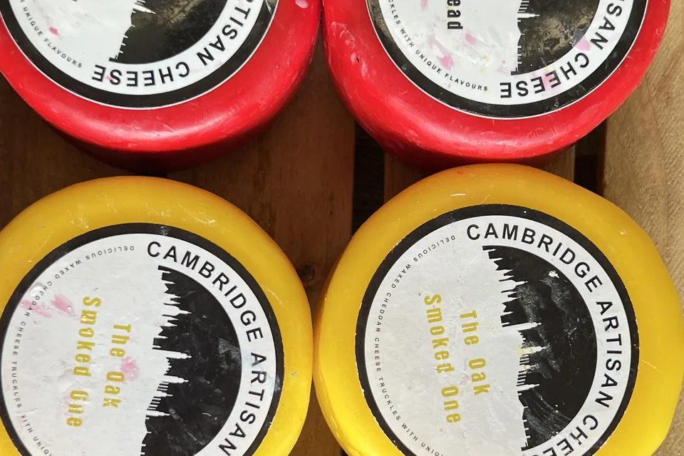 Cambridge Artisan Cheese waxed truckles in red and yellow: The Naan Bread One and The Oak Smoked One